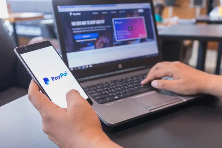 Pessoa verificando taxas do paypal em seu celular.