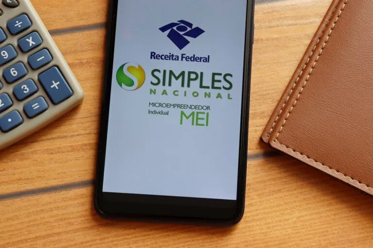 Imagem de um celular em cima da mesa com o aplicativo do Simples Nacional aberto na tela para fazer a Declaração Anual do Simples Nacional (DASN) até 31 de maio de 2023