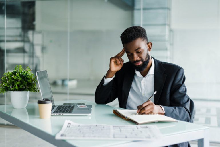 O que é bootstrapping: homem no escritório fazendo anotações no caderno