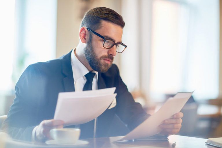 Governança corporativa: homem de negócios lendo documentos empresariais