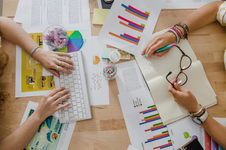 Economia Criativa: mulheres em uma mesa analisando dados