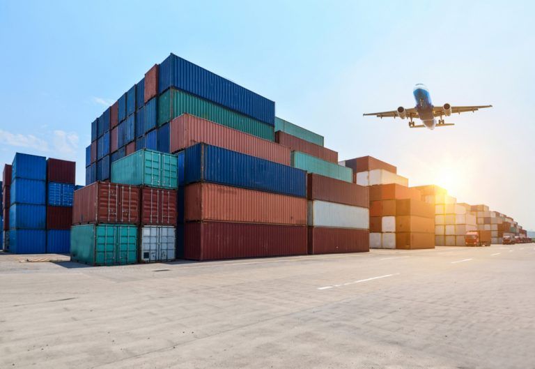 Exportação Aérea: avião decolando próximo a containers