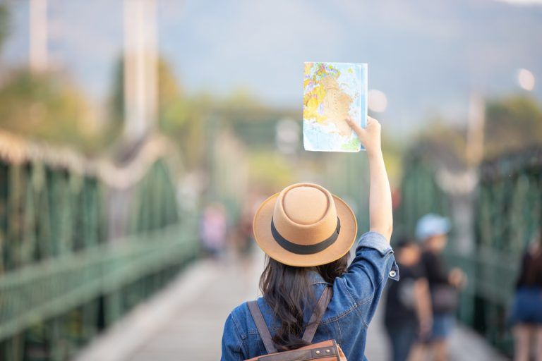 seguro viagem europa: mulher de costas, segurando um mapa.