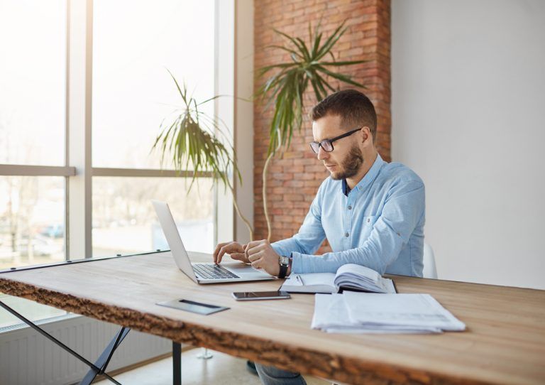 Valuation: Homem sentado, mexendo em um notebook.