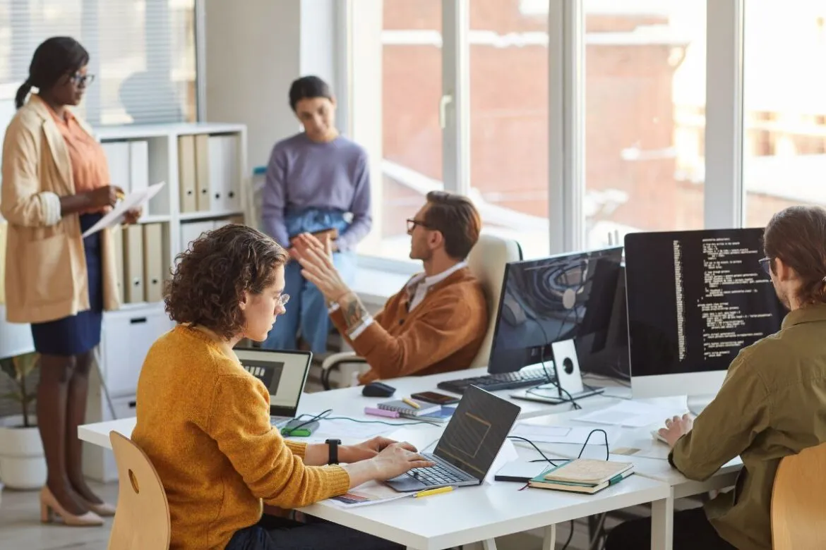 Funcionários em reunião sobre abrir empresa na Europa.