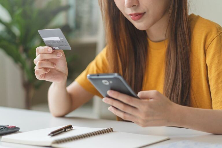 Mulher usando o smartphone para fazer compras no cartão