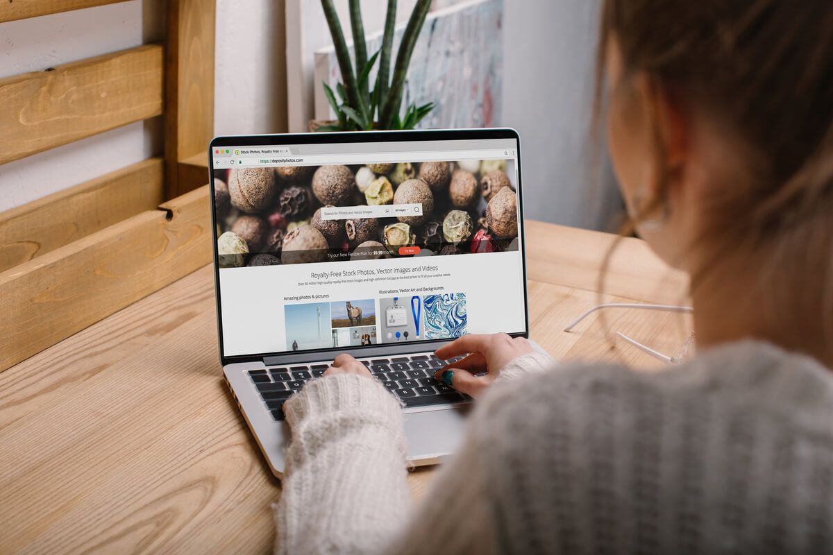 Menina mexendo em um banco de imagens grátis no laptop