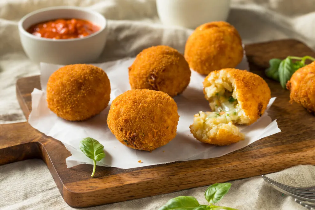 Culinária italiana: risoto caseiro Arancino frito com manjericão