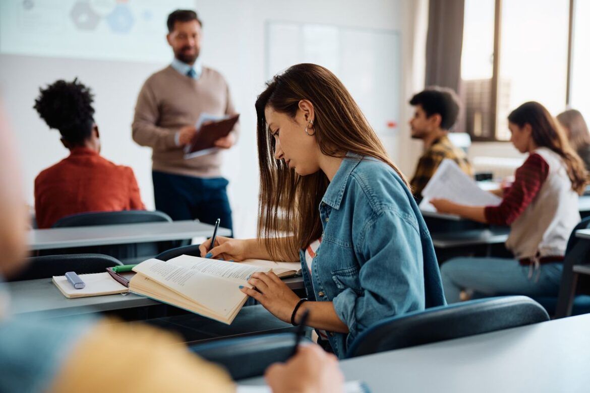 Estudante fazendo anotações na aula do doutorado no exterior.