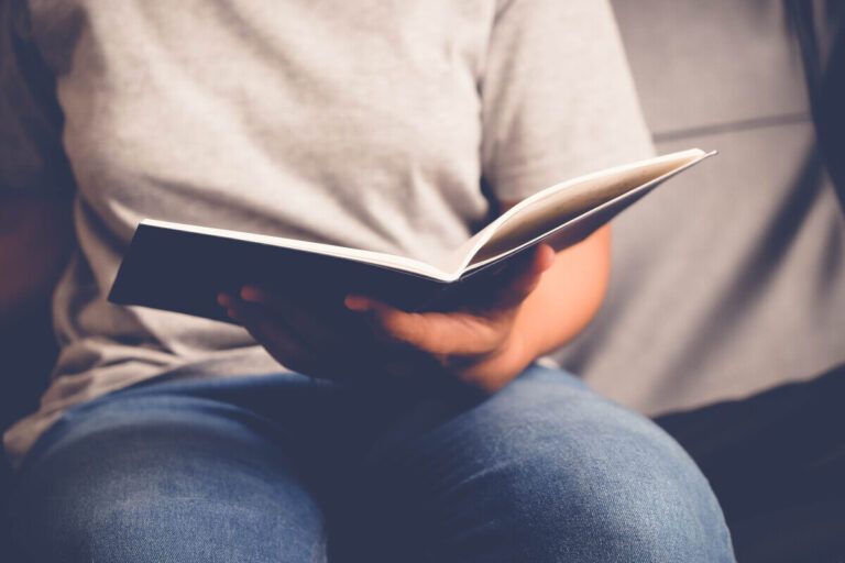 Mulher lendo livros sobre produtividade