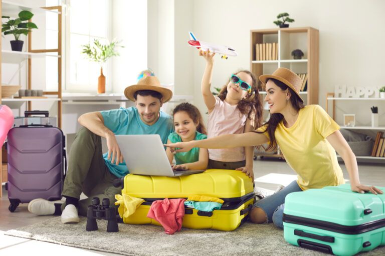 Família reunida na sala com malas de viagem e notebook