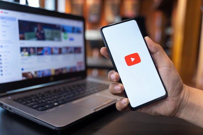 homem acessando o Youtube pelo celular e computador para tirar o strike do canal