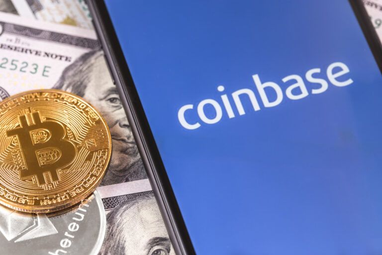 Um celular com o logo da Coinbase, um bitcoin ao lado e ao fundo notas de dólar