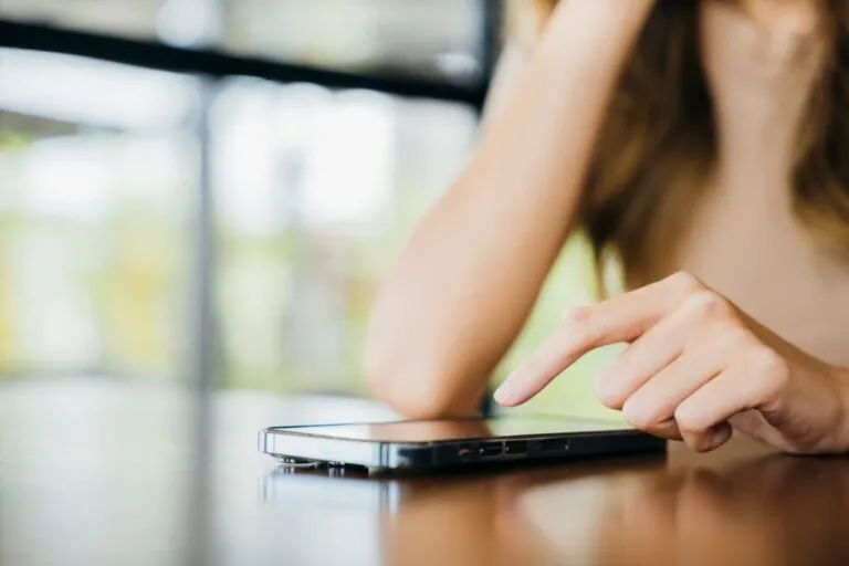 Mulher pesquisando no celular como receber dinheiro do exterior pelo PicPay.