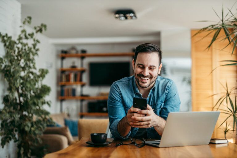 Um homem sorrindo para o telefone