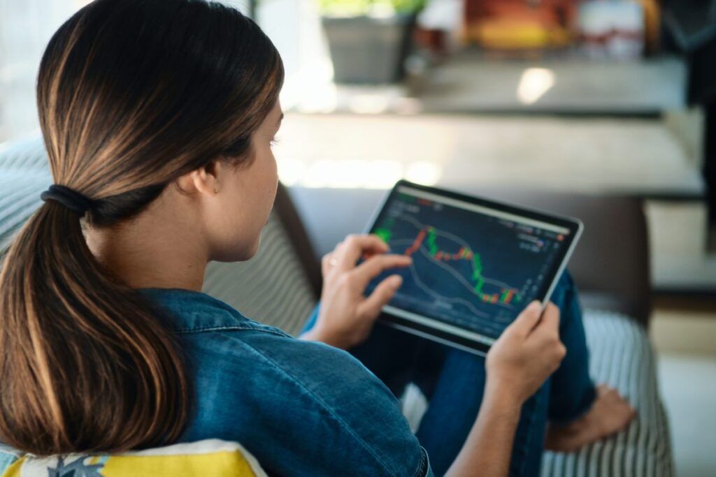 Mulher acessando a conta de investimentos no tablet.