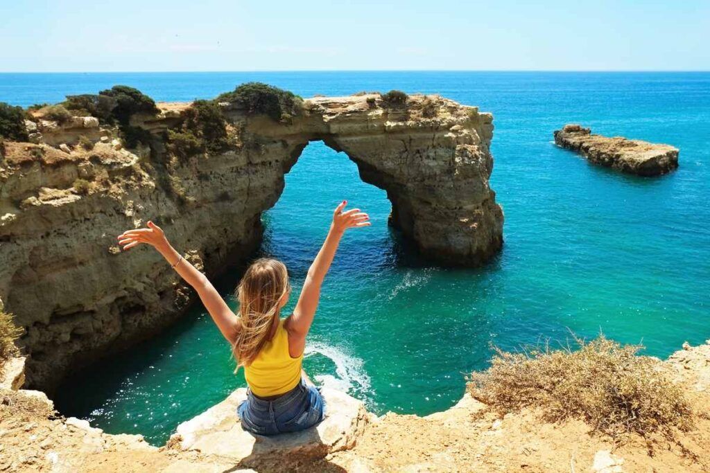 Praia do Algarve durante o verão e turista aproveitando o dia. 