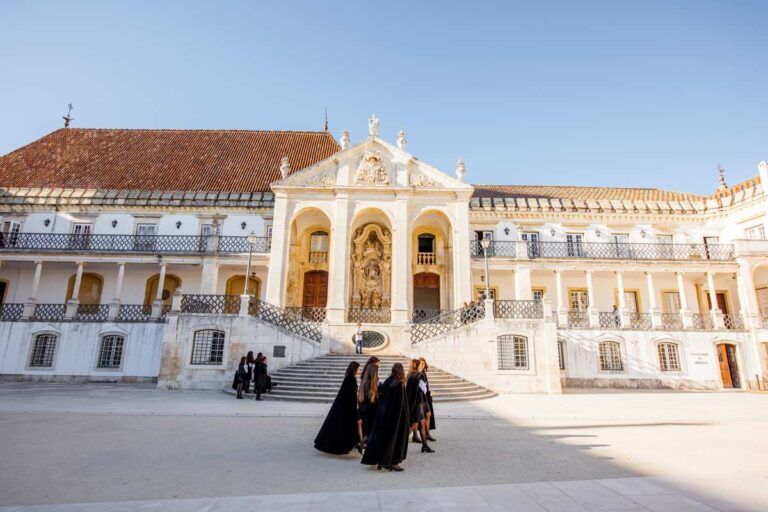 Estudantes caminhando na frente da Universidade de Coimbra