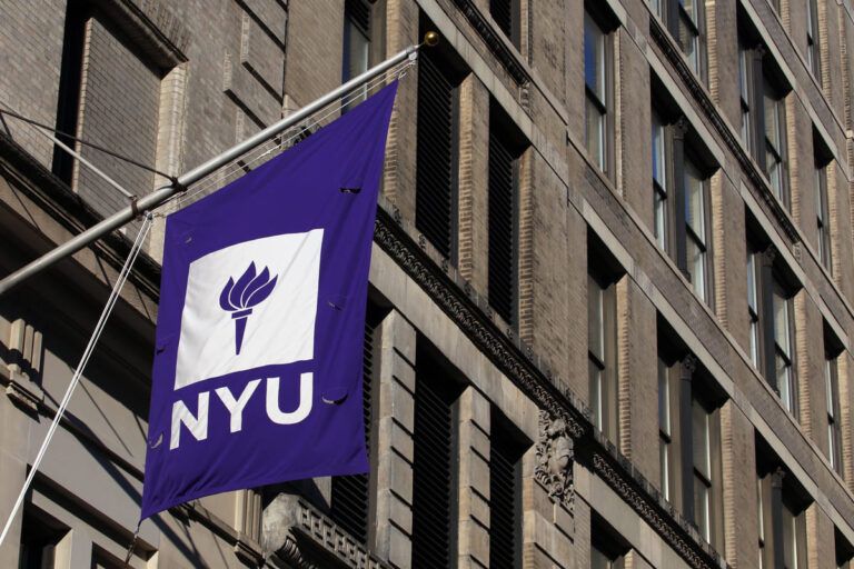 Bandeira da NYU fixada na fachada de um prédio da universidade.