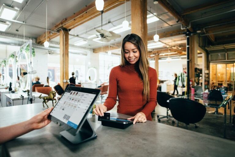 Mulher fazendo compra com um cartão da Brex Fintech.