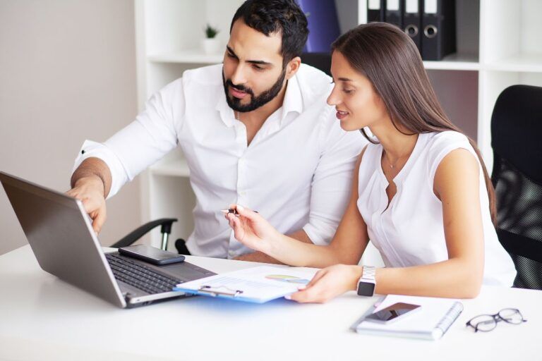 Homem e mulher em frente ao laptop aprendendo como sacar o dinheiro do Google Opinion Rewards.