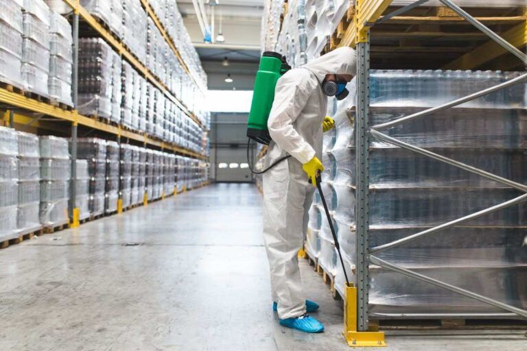 Homem fazendo a fumigação em produtos do galpão.