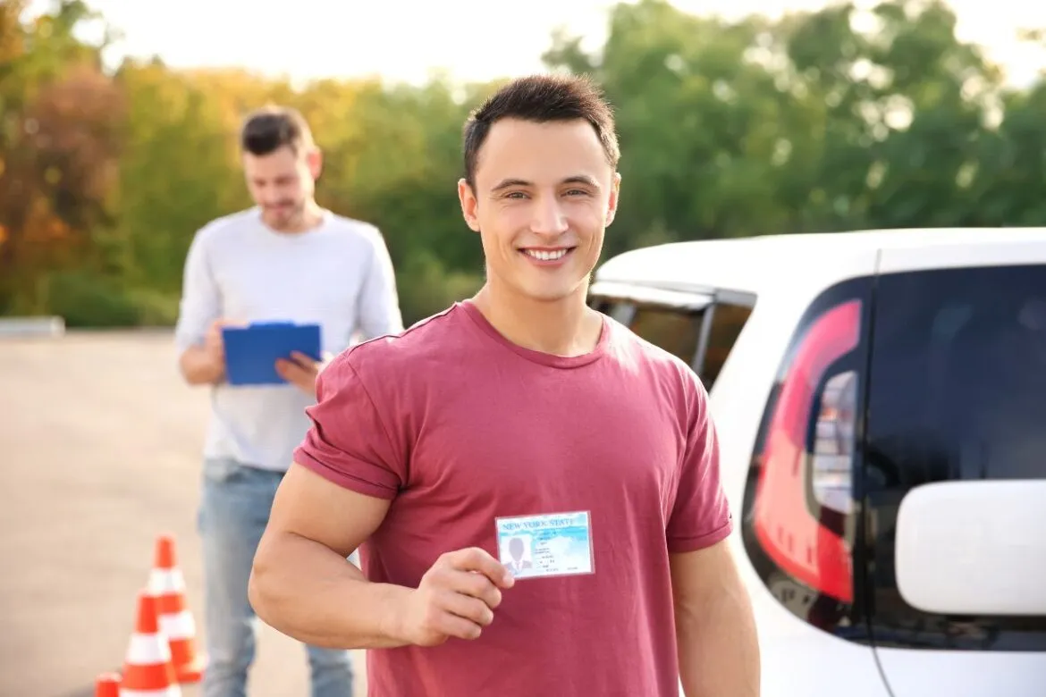 Homem feliz após tirar carteira de motorista no Japão.