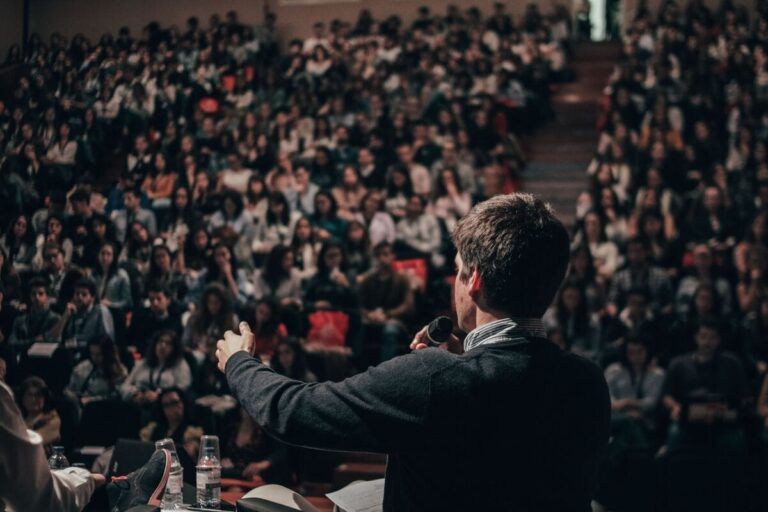 Homem durante palestra, simulando estar na EVOLVE 2023