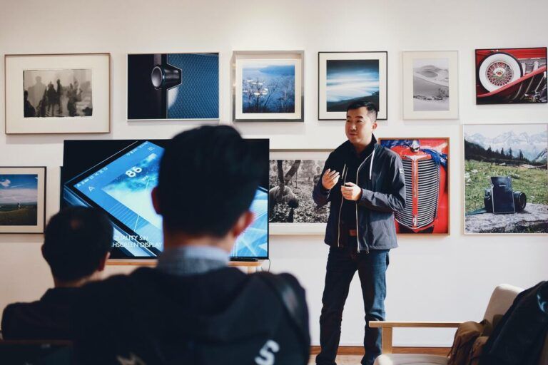 Homem dando uma palestra no evento Download 2023, um encontro para profissionais de viagens corporativas.