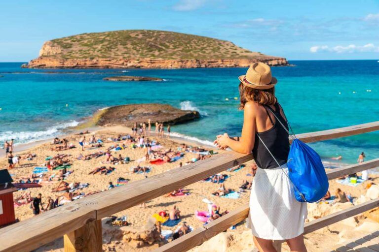 Jovem admirando a praia de Ibiza no verão.