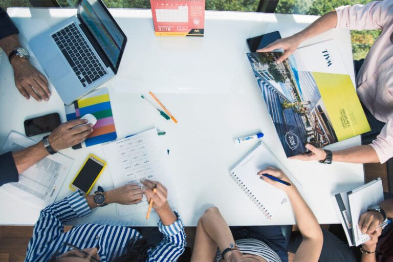 Pessoas sentadas em uma mesa para construir um briefing.