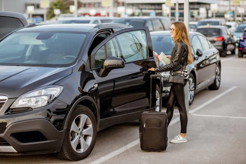 Viajante entrando no carro que alugou em Portugal. 