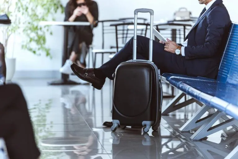 Executivo lendo jornal na sala VIP no aeroporto.