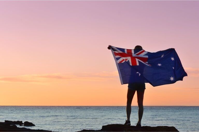 Pessoa segurando a bandeira da Austrália para falar sobre custo de vida na Austrália.