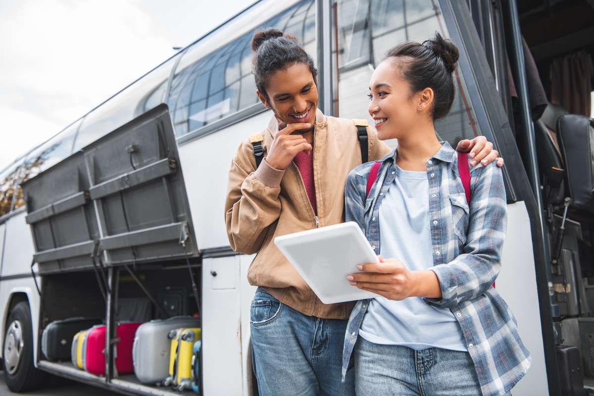 Homem e mulher comprando passagens no FlixBus na Europa pelo tablet.