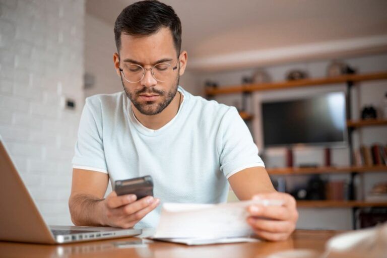 Homem pagando as contas para evitar a inadimplência.