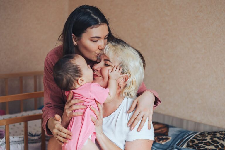 Mãe, filha e neta felizes se abraçando.