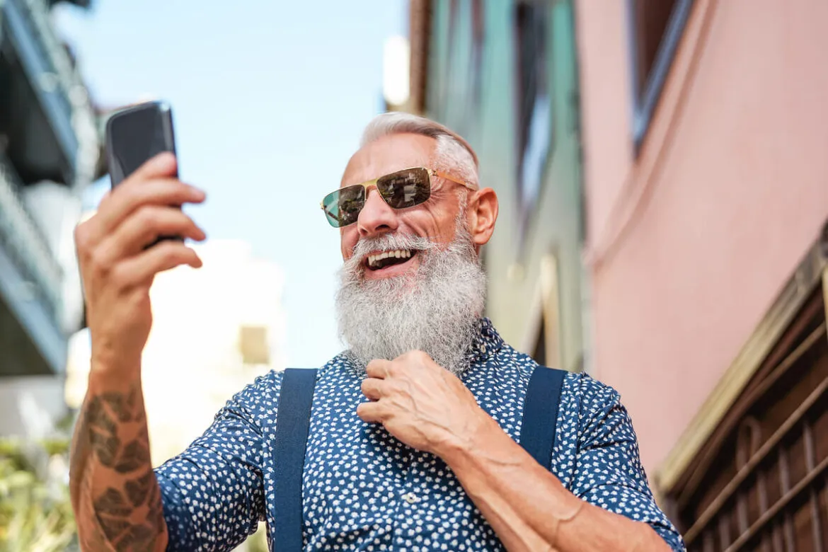 Homem idoso procurando saber como ganhar dinheiro no Instagram pelo celular.