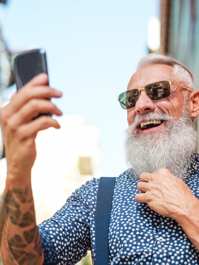 Homem idoso procurando saber como ganhar dinheiro no Instagram pelo celular.