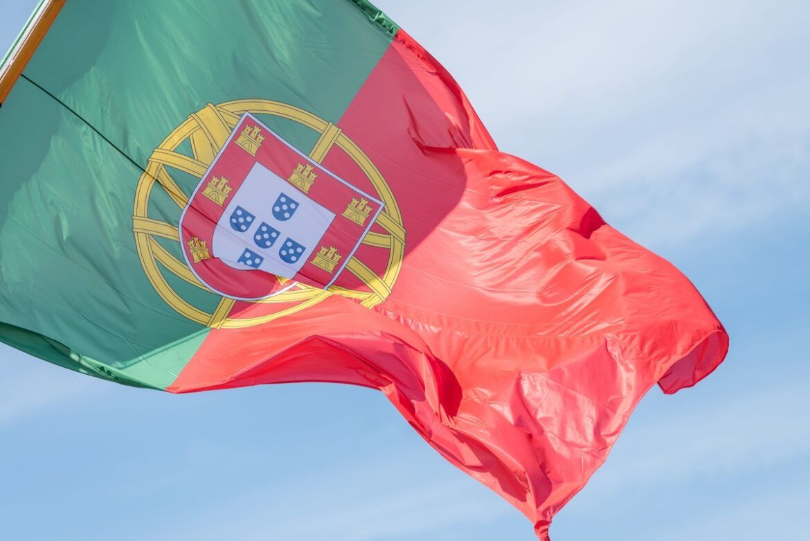 Foto de perto da bandeira de Portugal no fundo do céu