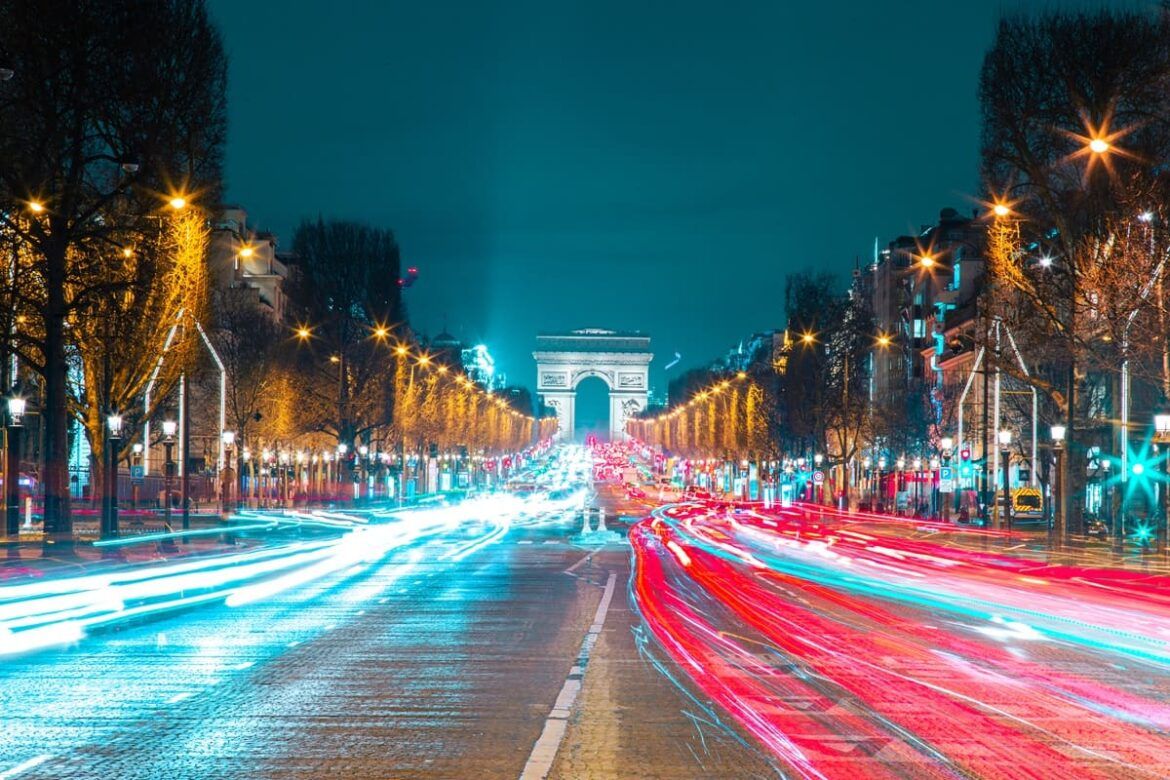 Avenida Champs-Élysées à noite com carros passando