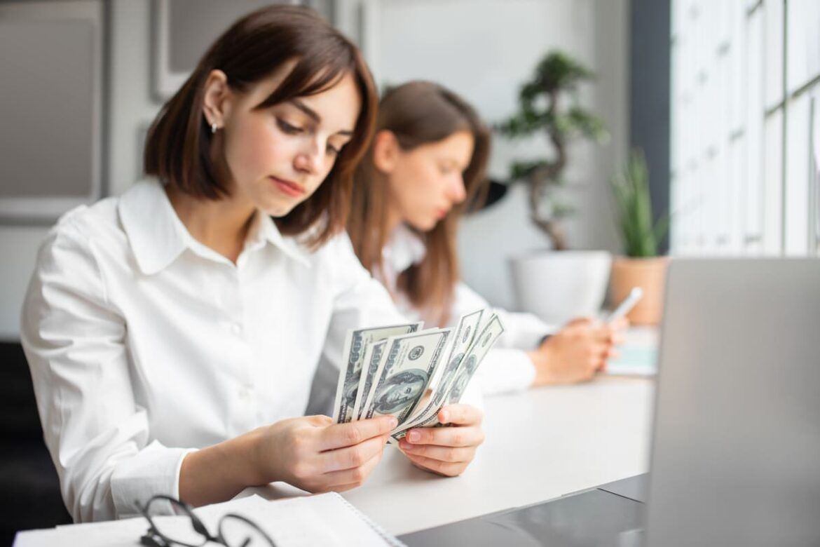 Mulher contando dinheiro para transferir para sua conta internacional Itaú.