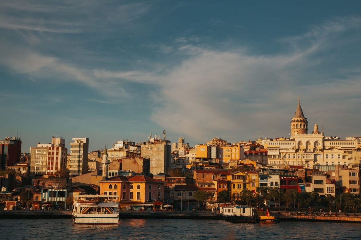 Paisagem diurna de Istambul, onde mostra construções, um rio e barcos.