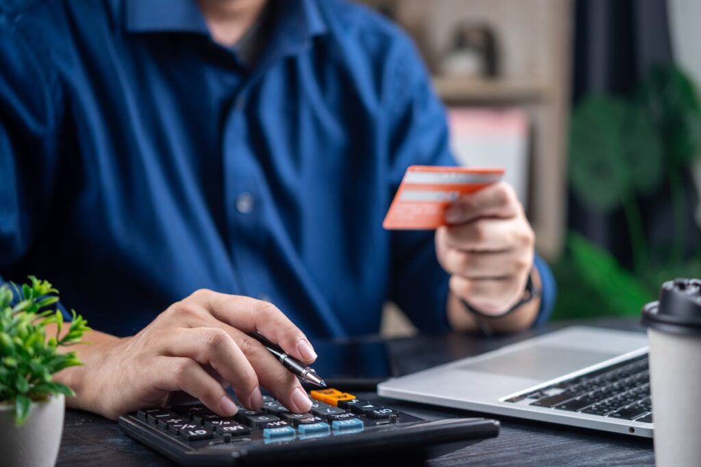 Homem calculando as taxas do cartão, antes de sacar dinheiro na Alemanha