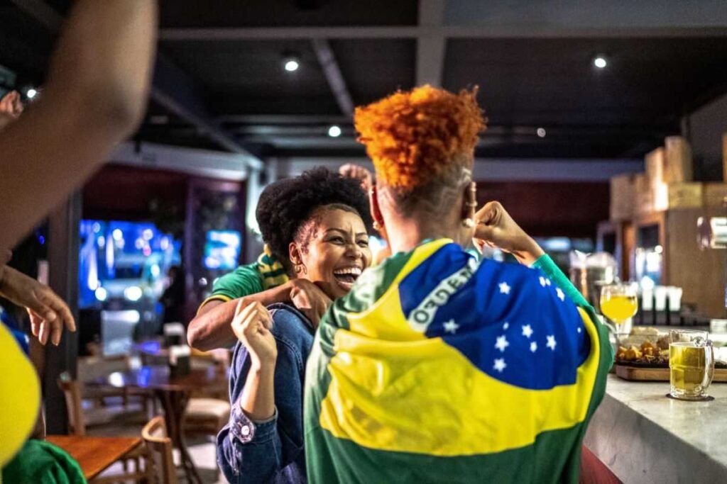 Torcedores brasileiros felizes no bar.