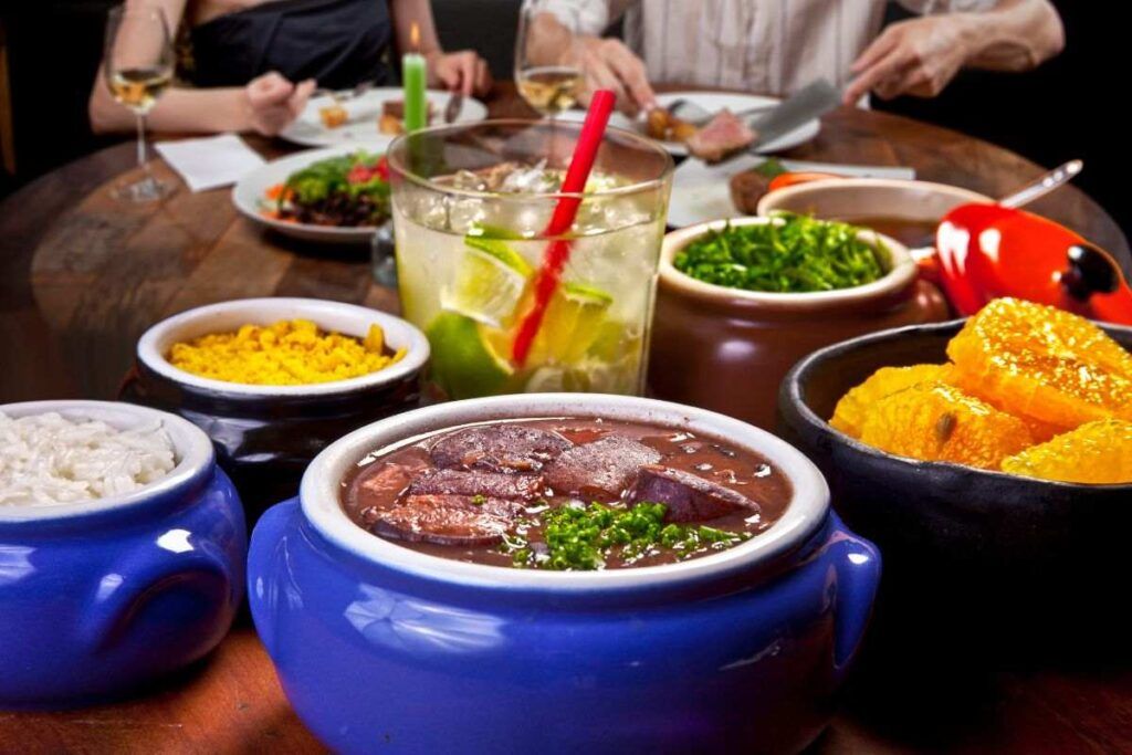 Duas pessoas comendo feijoada em um bar brasileiro em Paris. 