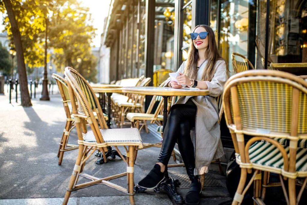 Mulher sentada tomando café em um dos melhores restaurantes em Paris. 