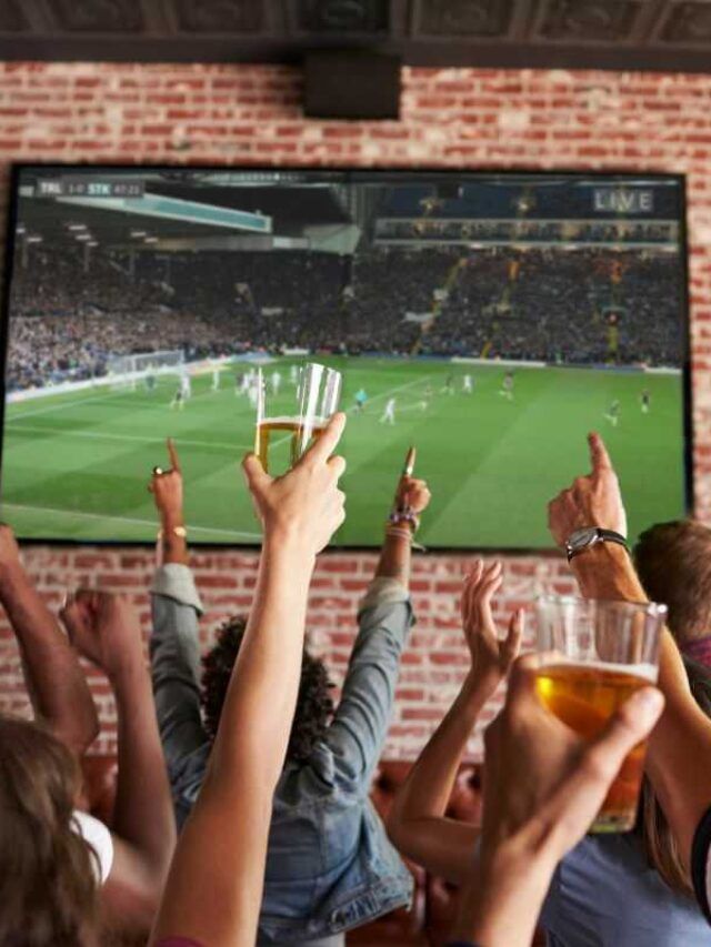 Fãs de futebol assistindo partida nas Olimpíadas em bar da cidade do Porto