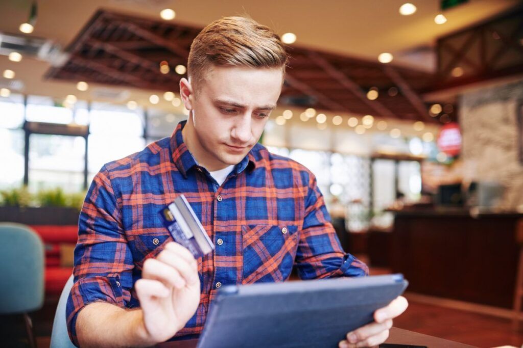 Homem fazendo compras online pelo tablet. 