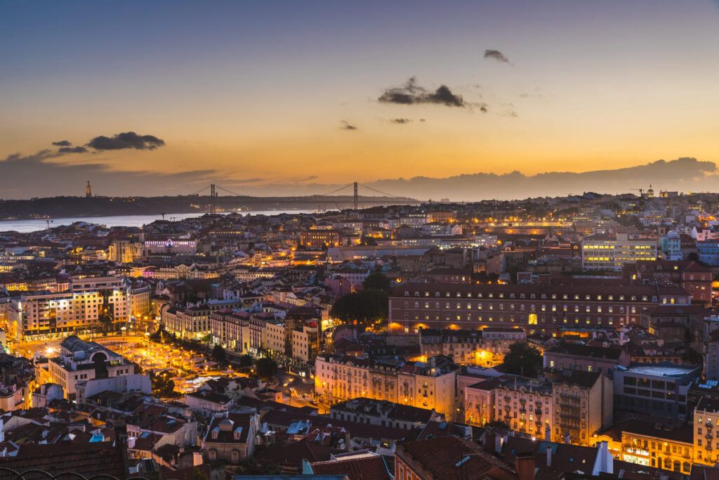 Imagem noturna de Lisboa, Portugal — país perto de Paris.